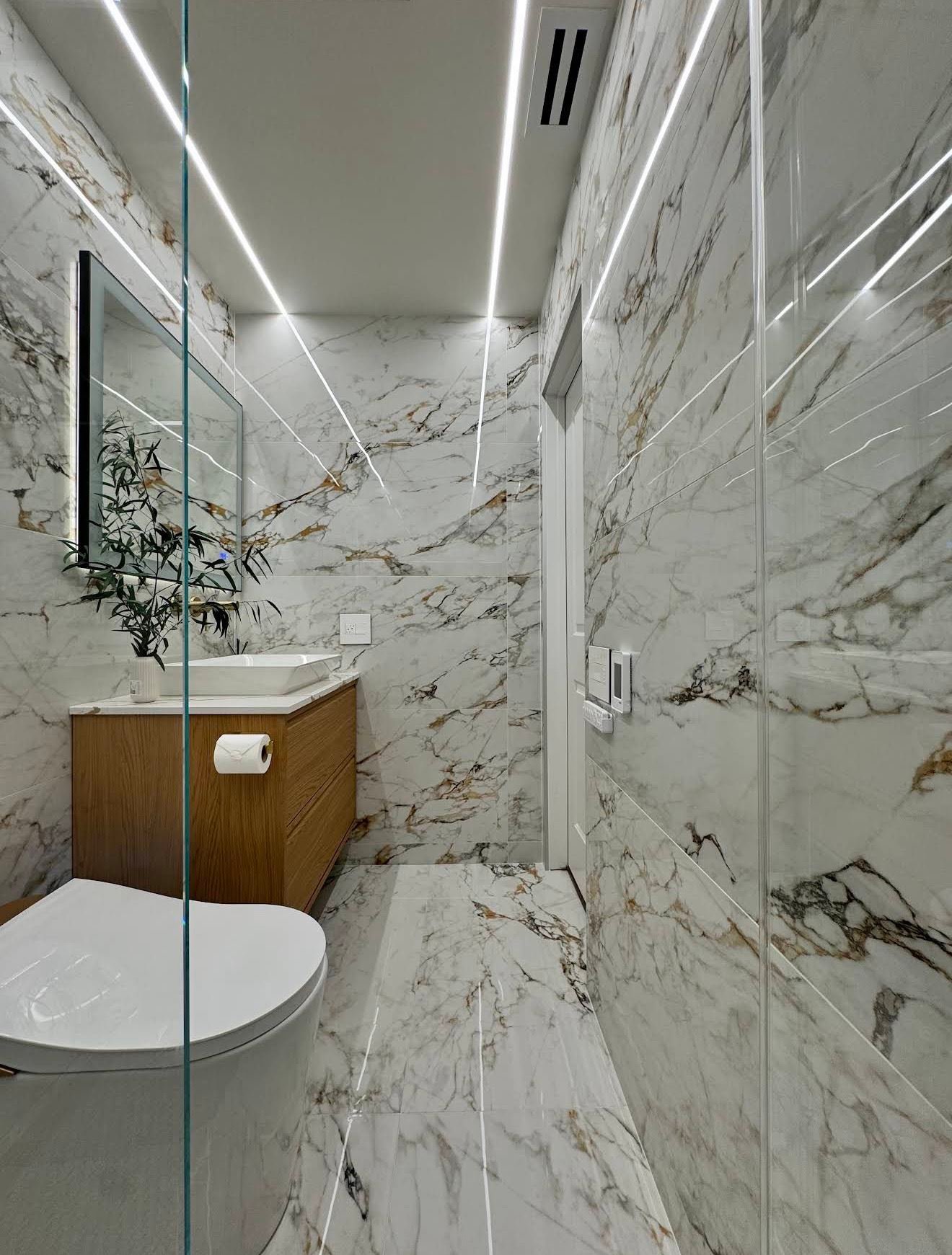 Premium marble bathroom with LED line lighting along walls and ceiling